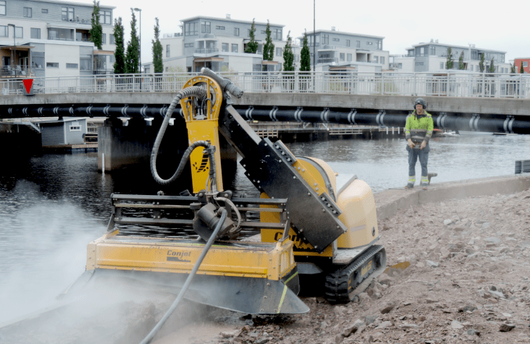 Conjet hydrodemolition robot removing damaged concrete using water jet technology for bridge repair and infrastructure restoration